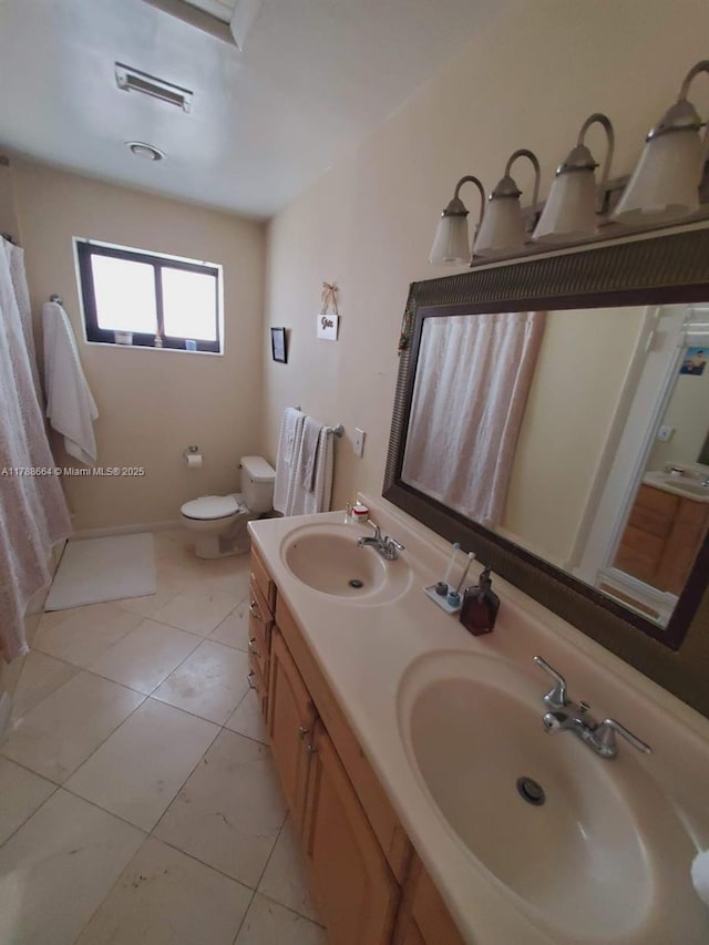 bathroom with double vanity, toilet, visible vents, and a sink
