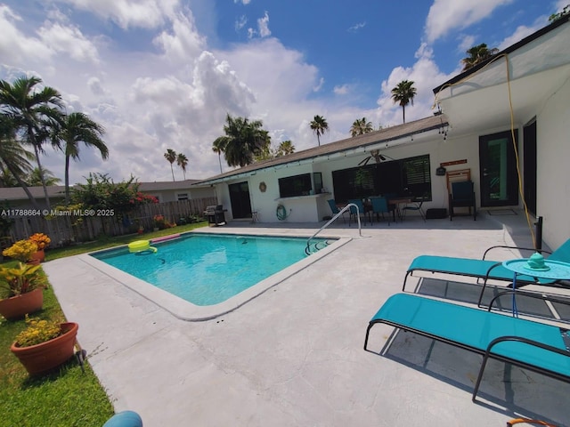 view of swimming pool with fence, a fenced in pool, a patio, and a grill