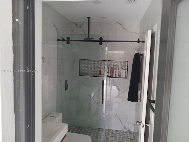 full bath with vanity, a marble finish shower, and toilet