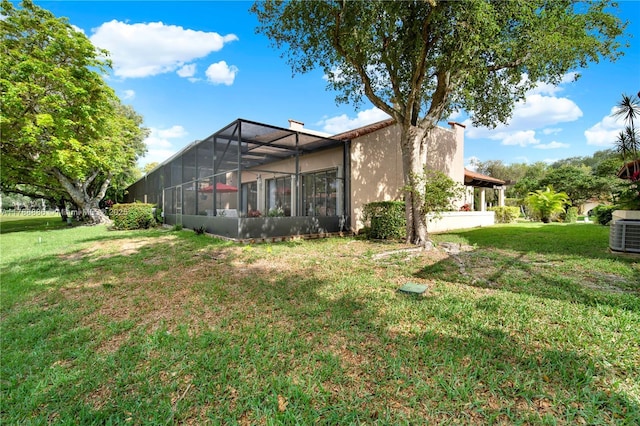 3939 Adra Ave Unit A-47, Doral, FL 33178 - rear view of house featuring a lawn, central AC unit, a lanai, and stucco siding