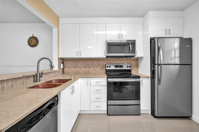 kitchen featuring a sink, white cabinetry, appliances with stainless steel finishes, and tasteful backsplash
