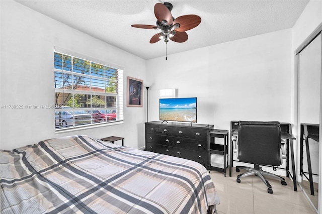 bedroom with a ceiling fan, a textured ceiling, and a closet