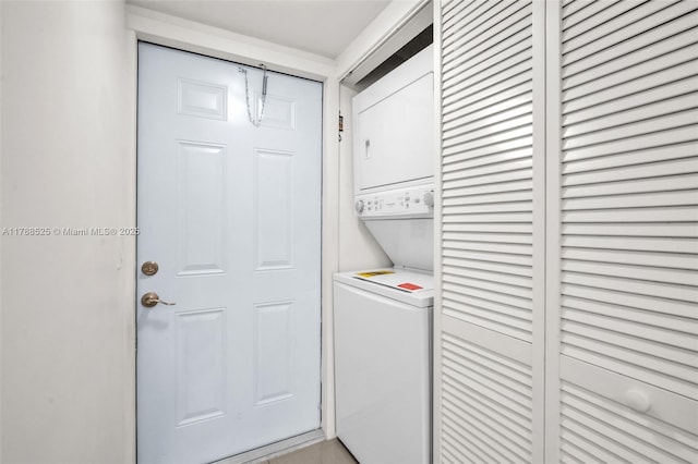 clothes washing area featuring stacked washer / drying machine and laundry area