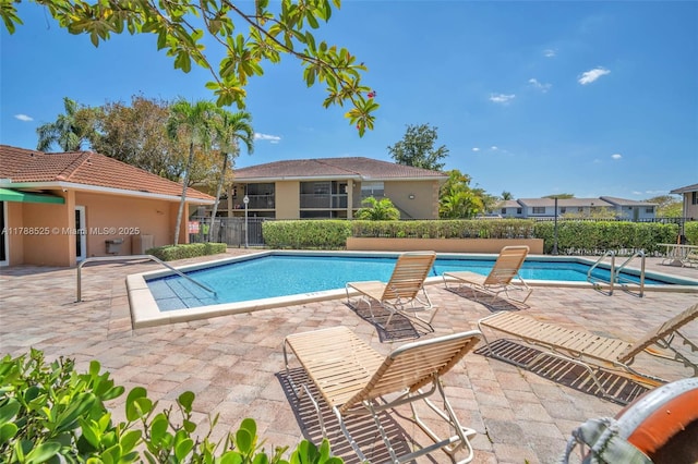 pool featuring fence and a patio area