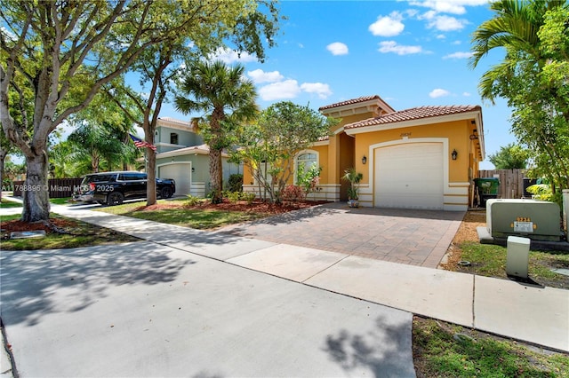 20656 SW 89th Ave, Cutler Bay, FL 33189 - mediterranean / spanish-style house featuring stucco siding, fence, decorative driveway, a tile roof, and an attached garage