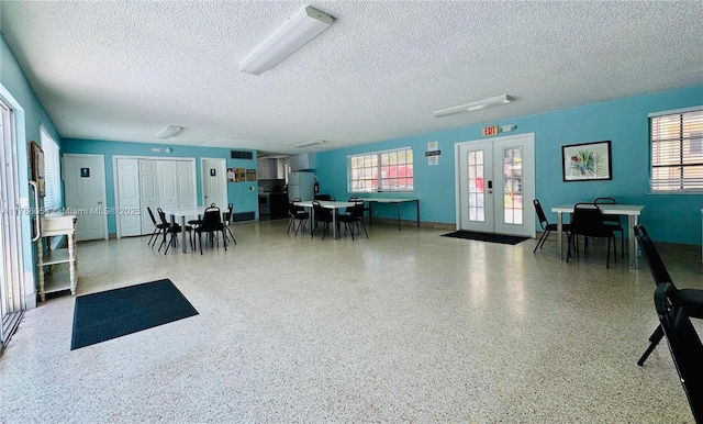 450 E Paradise Isle Blvd Unit 208, Hallandale Beach, FL 33009 - misc room featuring french doors, healthy amount of natural light, a textured ceiling, and speckle patterned floor