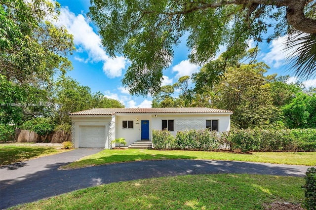 6845 SW 57th Ter, Miami, FL 33143 - view of front of home with stucco siding, an attached garage, a tiled roof, and a front lawn