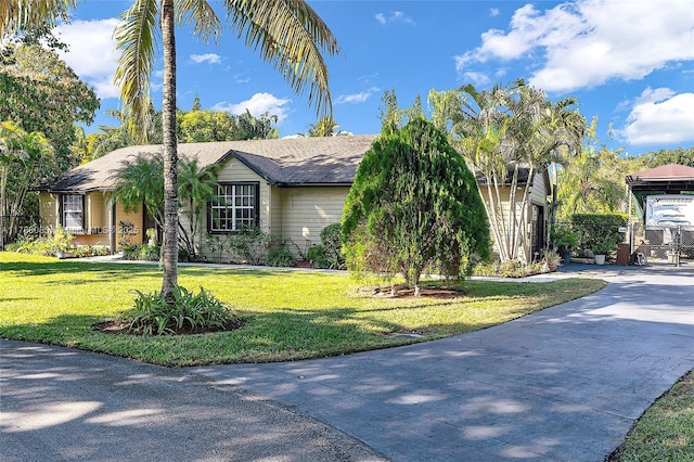 view of front of property with fence, driveway, and a front lawn