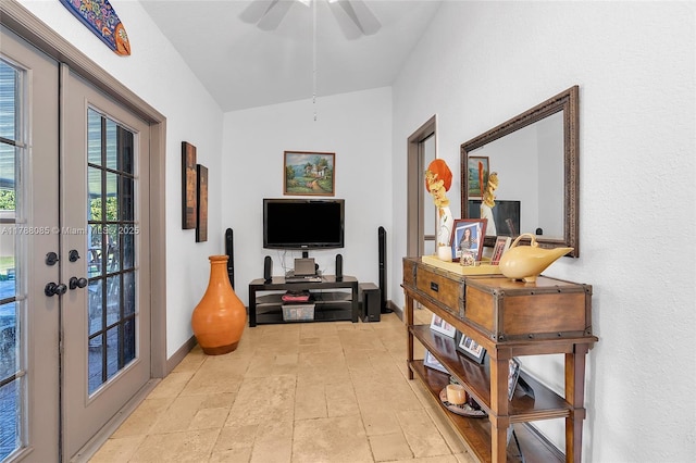 interior space with lofted ceiling, french doors, baseboards, and stone tile flooring