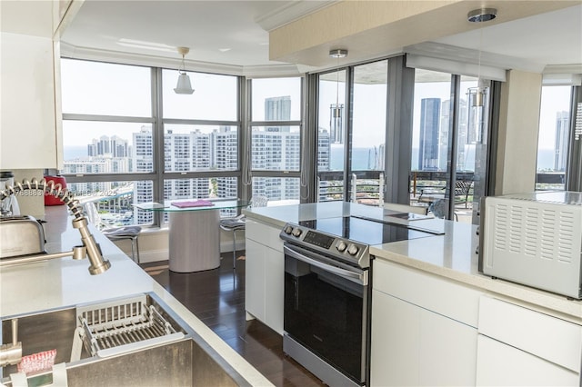 3530 Mystic Pointe Dr Unit 2910, Aventura, FL 33180 - kitchen featuring stainless steel electric range, a view of city, dark wood finished floors, white cabinetry, and hanging light fixtures