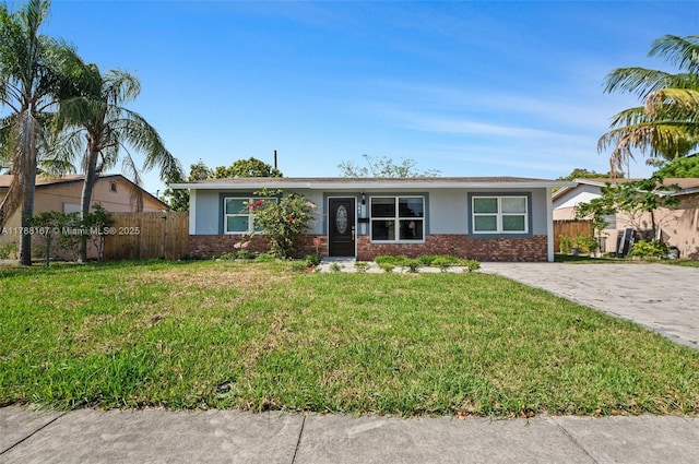 single story home with brick siding, stucco siding, a front lawn, and fence