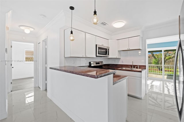 kitchen featuring dark countertops, visible vents, a sink, crown molding, and appliances with stainless steel finishes