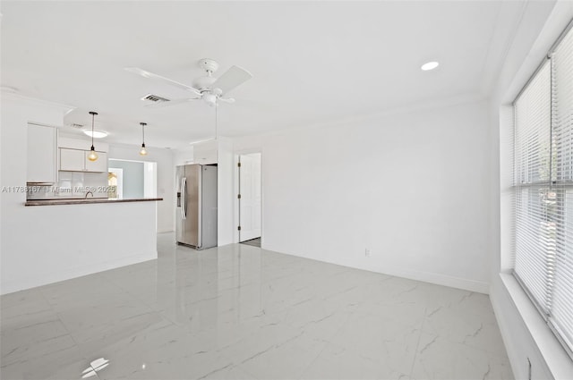 unfurnished living room featuring crown molding, marble finish floor, ceiling fan, baseboards, and visible vents