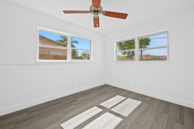 unfurnished room featuring baseboards, wood finished floors, and ceiling fan