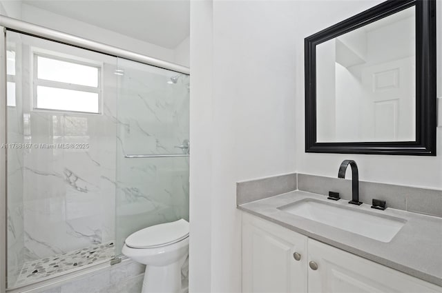 full bathroom with a marble finish shower, vanity, and toilet