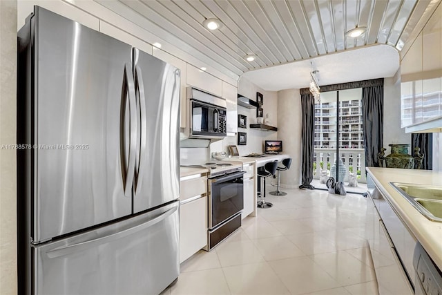 3000 Island Blvd Unit 706, Aventura, FL 33160 - kitchen with appliances with stainless steel finishes, light countertops, white cabinetry, light tile patterned flooring, and recessed lighting