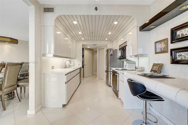 3000 Island Blvd Unit 706, Aventura, FL 33160 - kitchen featuring modern cabinets, range, white cabinets, light countertops, and black microwave