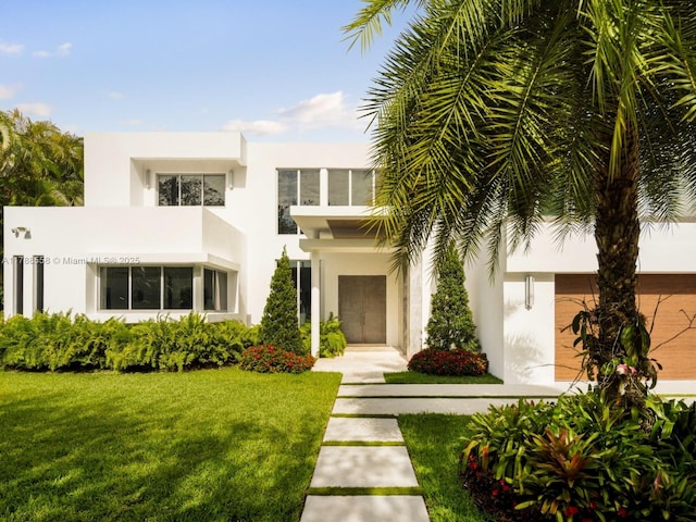 art deco home featuring stucco siding and a front lawn