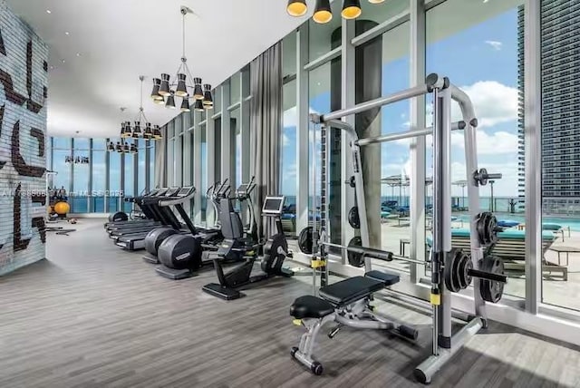4111 S Ocean Dr Unit 1801, Hollywood, FL 33019 - workout area with a wall of windows, wood finished floors, and an inviting chandelier