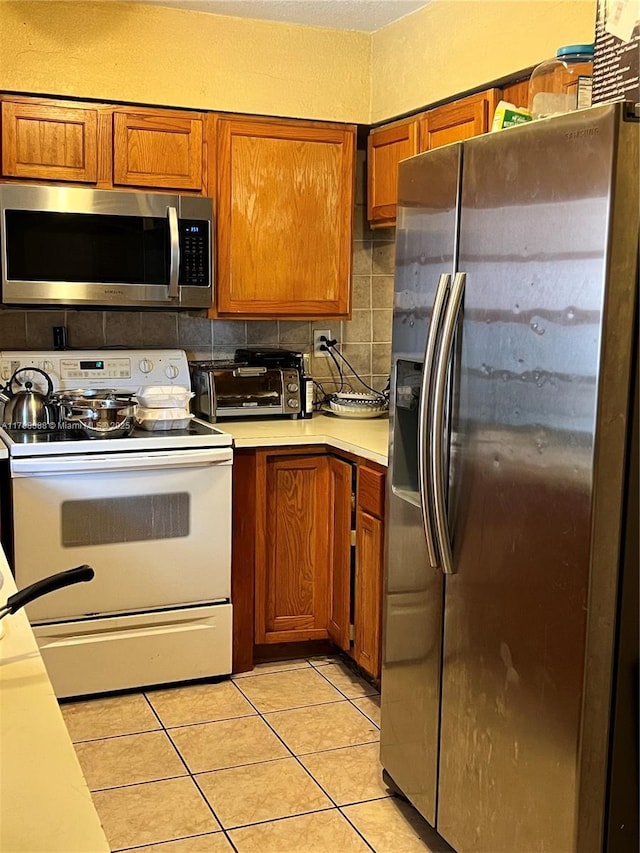 3530 NW 194th Ter, Miami Gardens, FL 33056 - kitchen with brown cabinets, a toaster, light countertops, tasteful backsplash, and appliances with stainless steel finishes