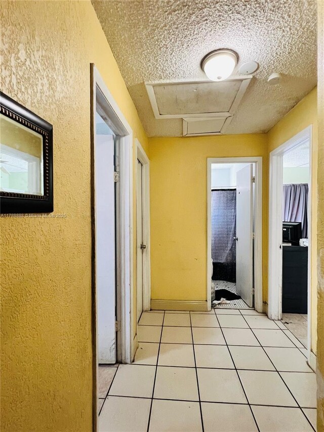 3530 NW 194th Ter, Miami Gardens, FL 33056 - hall with a textured wall, attic access, a textured ceiling, and light tile patterned flooring