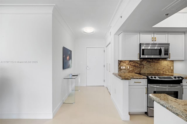 kitchen with white cabinets, stone counters, appliances with stainless steel finishes, and decorative backsplash