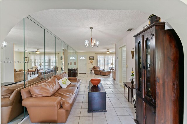 11421 NW 37th Pl, Sunrise, FL 33323 - living area featuring ceiling fan, light tile patterned floors, arched walkways, a chandelier, and a textured ceiling