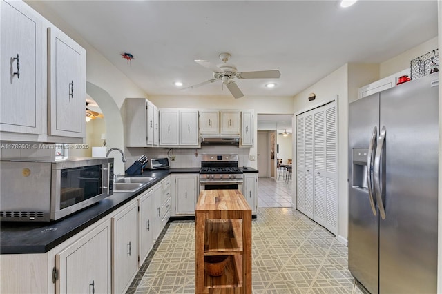 11421 NW 37th Pl, Sunrise, FL 33323 - kitchen with appliances with stainless steel finishes, a ceiling fan, a sink, decorative backsplash, and arched walkways
