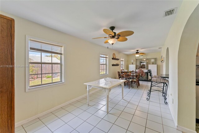 11421 NW 37th Pl, Sunrise, FL 33323 - dining space with arched walkways, a ceiling fan, baseboards, and light tile patterned floors