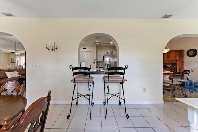 11421 NW 37th Pl, Sunrise, FL 33323 - dining space featuring ceiling fan, arched walkways, baseboards, and light tile patterned flooring