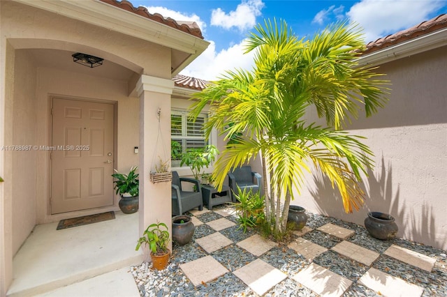 property entrance featuring stucco siding and a tiled roof