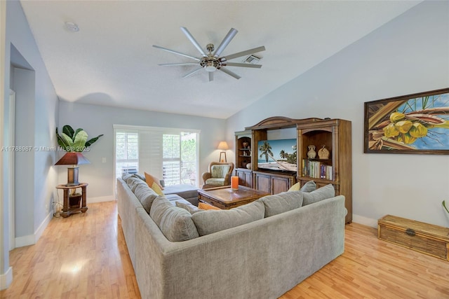 living room featuring a ceiling fan, visible vents, vaulted ceiling, and light wood-style floors