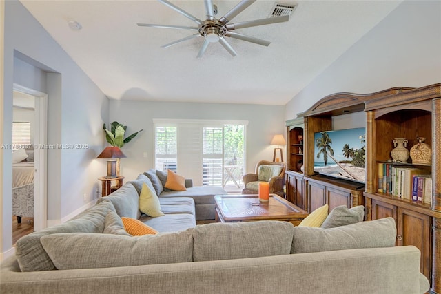 living area with lofted ceiling, visible vents, and a ceiling fan