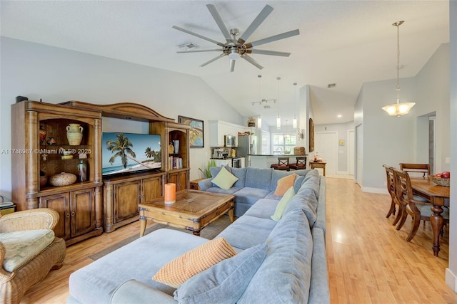 living area with visible vents, ceiling fan, light wood-style floors, and lofted ceiling