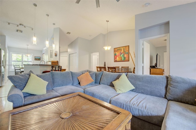 living room with track lighting, visible vents, a ceiling fan, and lofted ceiling
