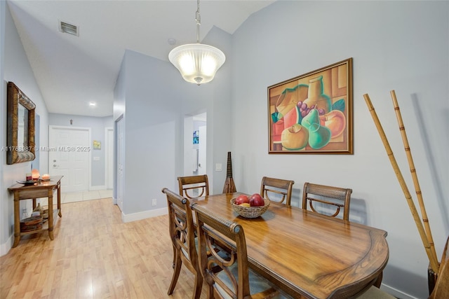 dining area featuring light wood finished floors, visible vents, and baseboards
