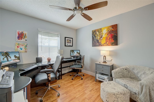 office area featuring light wood finished floors, a textured ceiling, ceiling fan, and baseboards