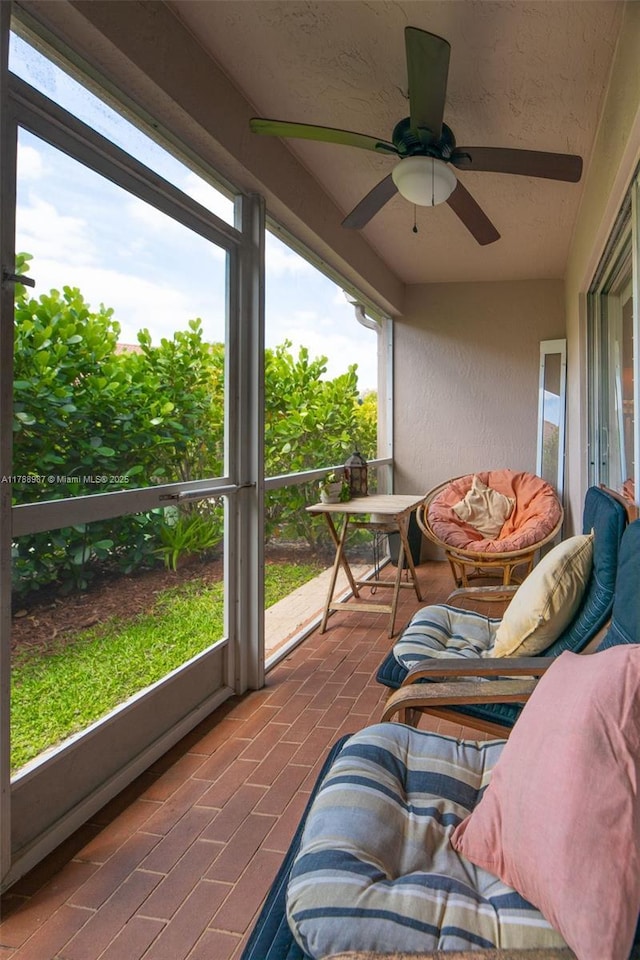 sunroom featuring a ceiling fan