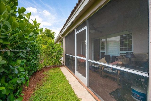 view of side of property featuring a sunroom and a tiled roof
