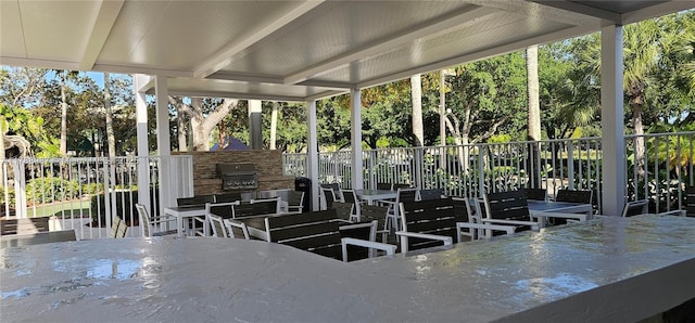 exterior space featuring fence, outdoor dining area, and an outdoor kitchen