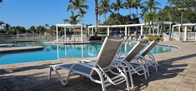 pool featuring fence and a patio area