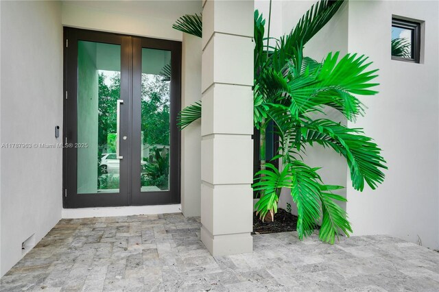 1733 NE 16th Ter, Fort Lauderdale, FL 33305 - view of exterior entry with stucco siding and french doors
