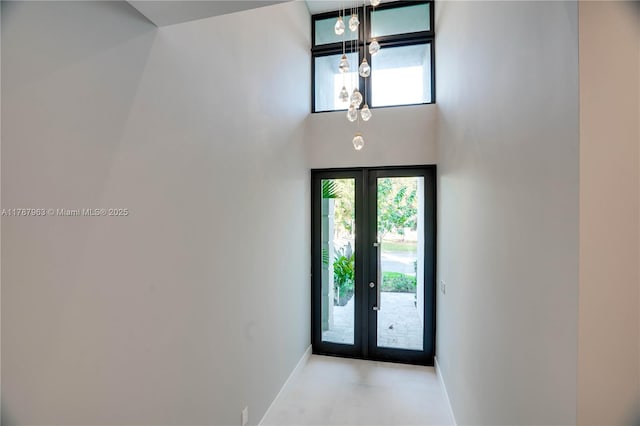 1733 NE 16th Ter, Fort Lauderdale, FL 33305 - foyer entrance featuring french doors, baseboards, a high ceiling, and a chandelier