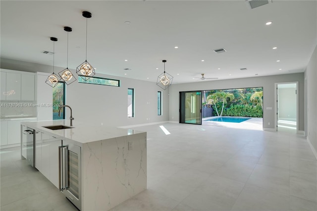 1733 NE 16th Ter, Fort Lauderdale, FL 33305 - kitchen with white cabinets, wine cooler, a sink, and modern cabinets
