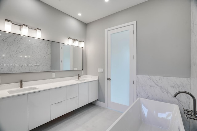 1733 NE 16th Ter, Fort Lauderdale, FL 33305 - full bath with double vanity, a freestanding tub, tile walls, and a sink