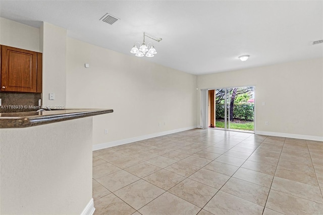 unfurnished room featuring light tile patterned flooring, visible vents, baseboards, and an inviting chandelier