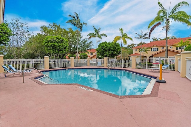community pool featuring a patio area and fence