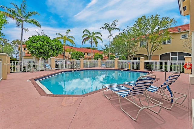 community pool with fence and a patio area