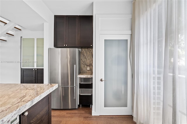 1600 Michigan Ave Unit 7, Miami Beach, FL 33139 - kitchen featuring freestanding refrigerator, dark brown cabinetry, wood finished floors, tasteful backsplash, and light stone countertops