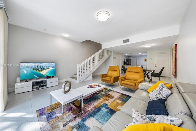 living room with stairway, tile patterned floors, and visible vents